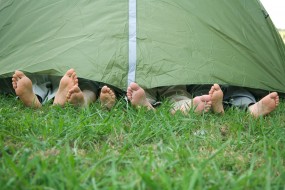 Young friends in tent, feet sticking out